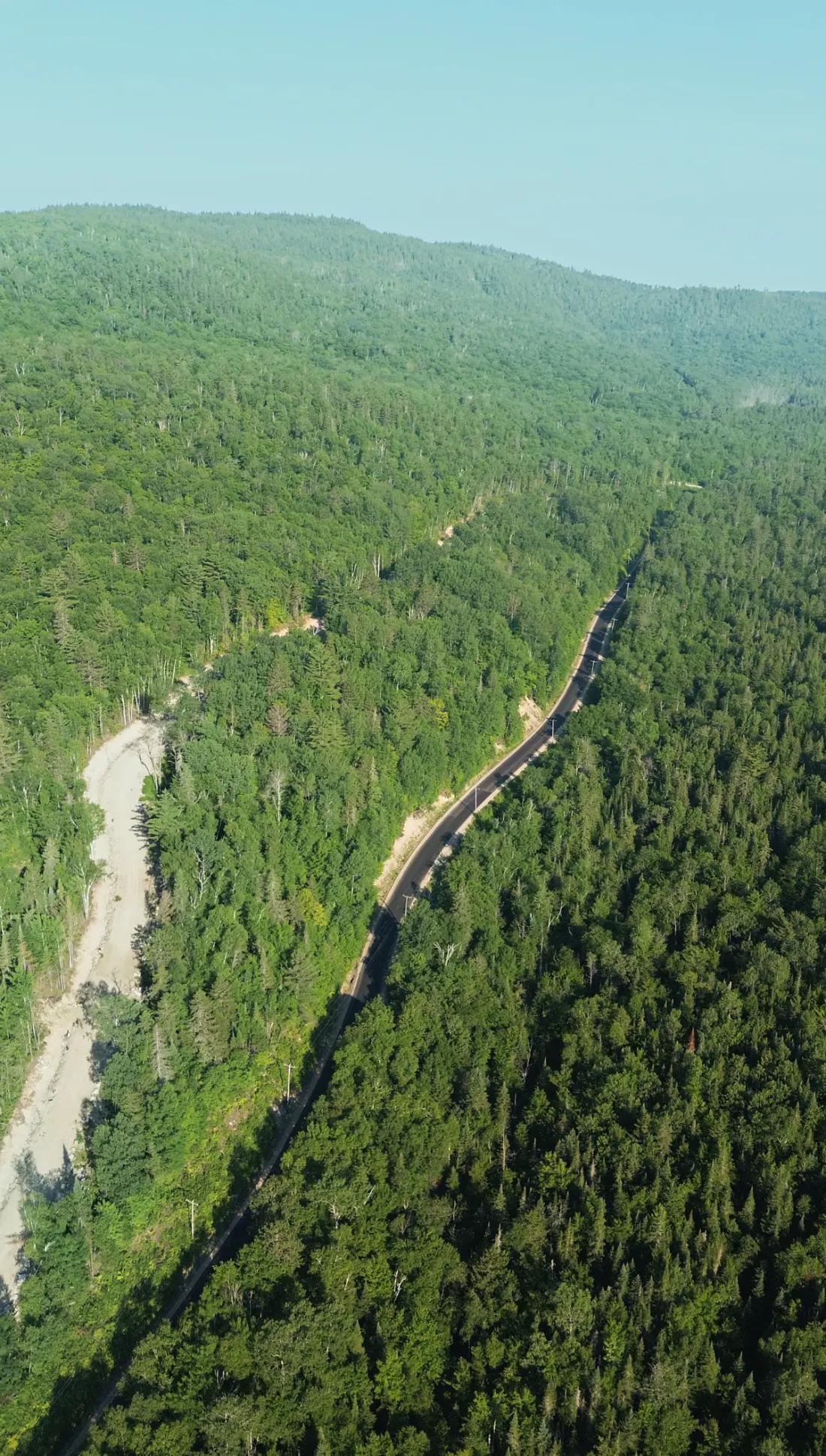 Vue aérienne du secteur : une route qui traverse la forêt en montagne